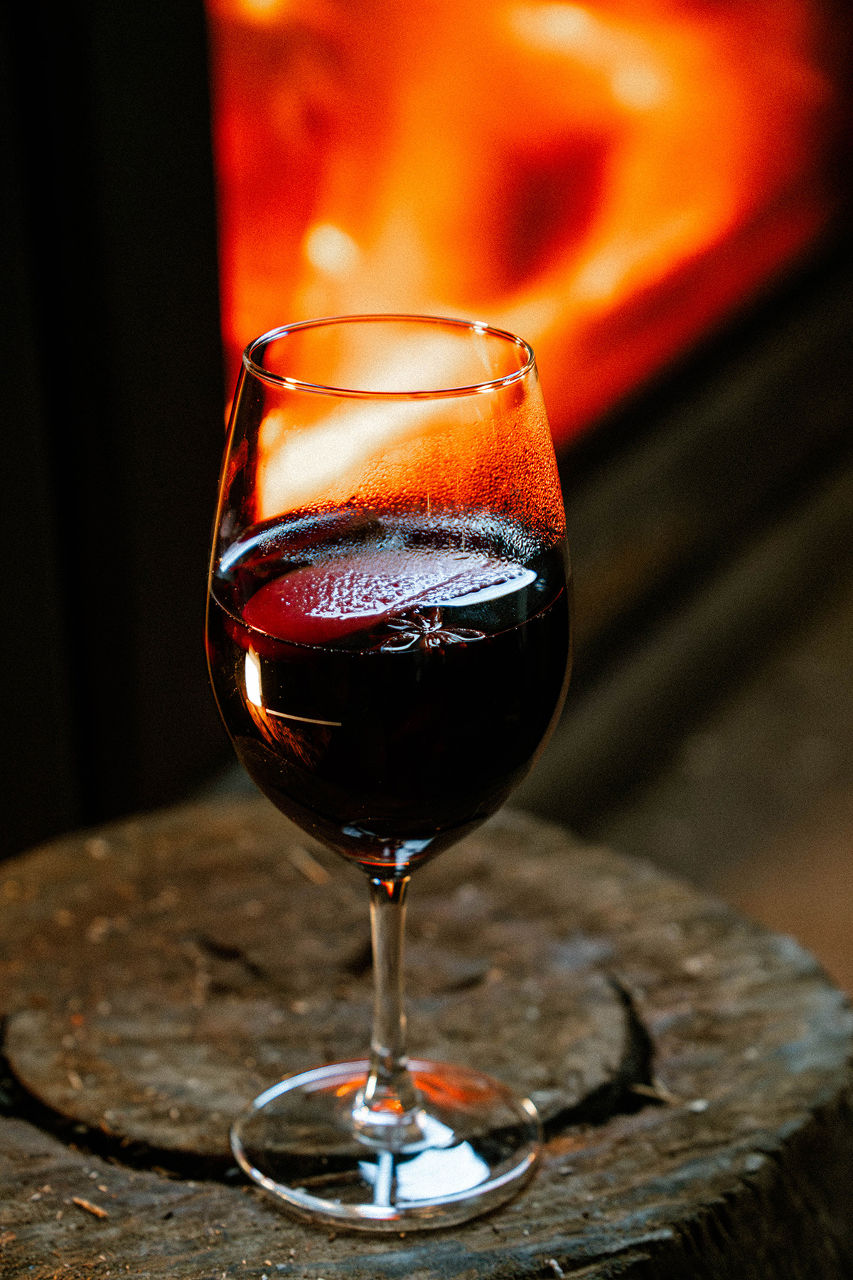 Glass of red wine beside the fireplace at Goat House