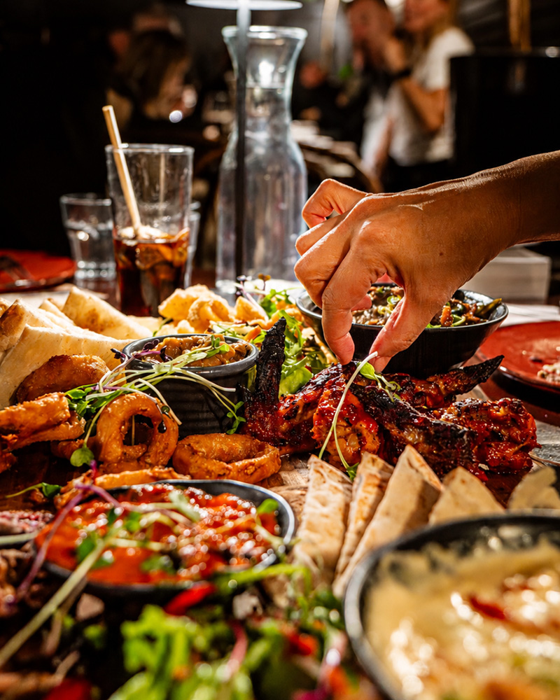 Guests sharing colourful dishes together at Goat House